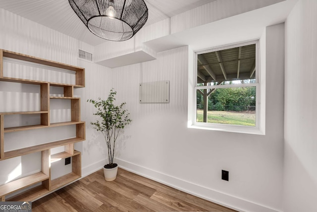 interior space with wood-type flooring and an inviting chandelier