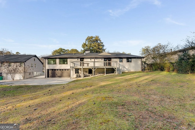 back of property with a deck, a garage, and a lawn