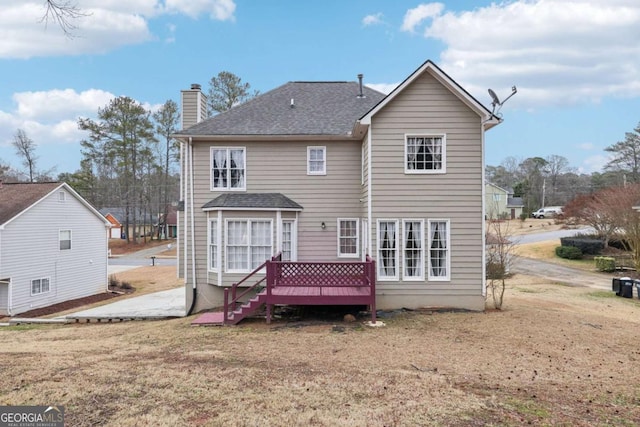 rear view of property with a yard and a wooden deck