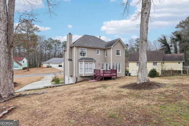 back of property featuring a lawn and a deck