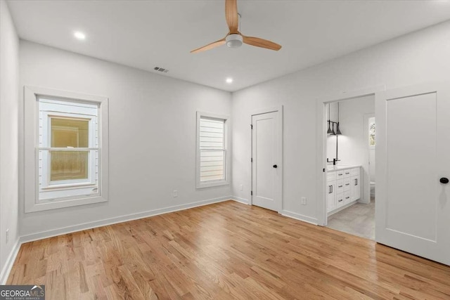 unfurnished bedroom featuring ensuite bathroom, light hardwood / wood-style floors, and ceiling fan