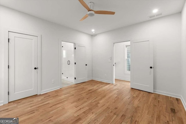 unfurnished bedroom featuring light wood-type flooring, ensuite bathroom, and ceiling fan