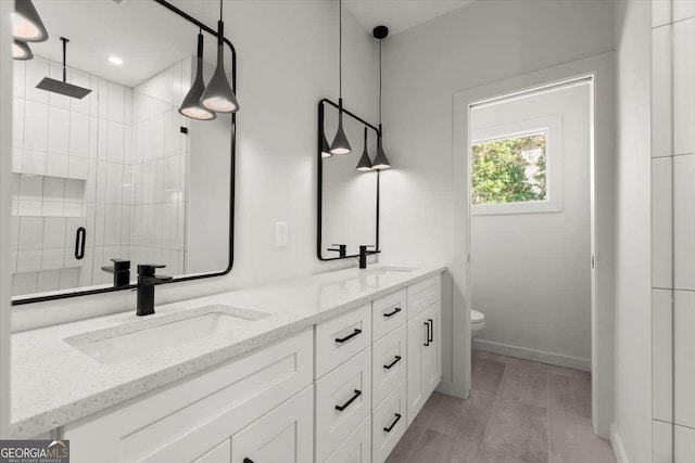 bathroom with vanity, a shower with shower door, and toilet