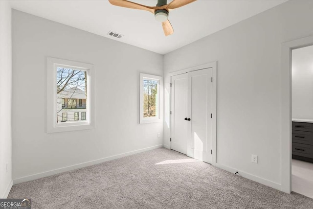 unfurnished bedroom featuring light colored carpet and ceiling fan