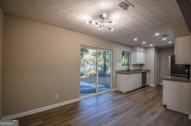 kitchen featuring hardwood / wood-style floors, dark stone counters, white cabinets, sink, and appliances with stainless steel finishes