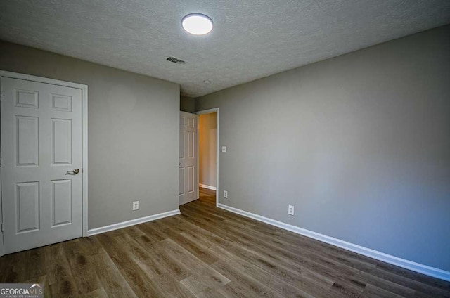 unfurnished bedroom with wood-type flooring and a textured ceiling