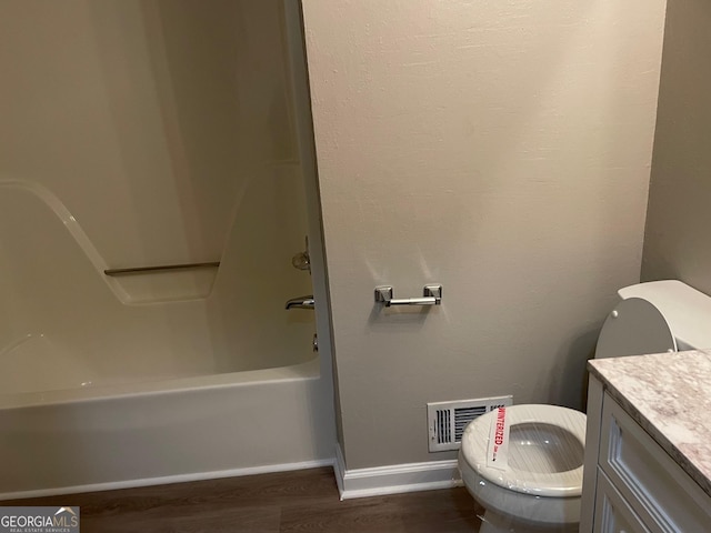 bathroom featuring vanity, wood-type flooring, and washtub / shower combination