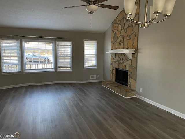 unfurnished living room with a fireplace, lofted ceiling, ceiling fan with notable chandelier, and a healthy amount of sunlight