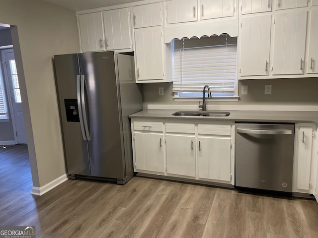 kitchen featuring hardwood / wood-style flooring, white cabinetry, sink, and appliances with stainless steel finishes