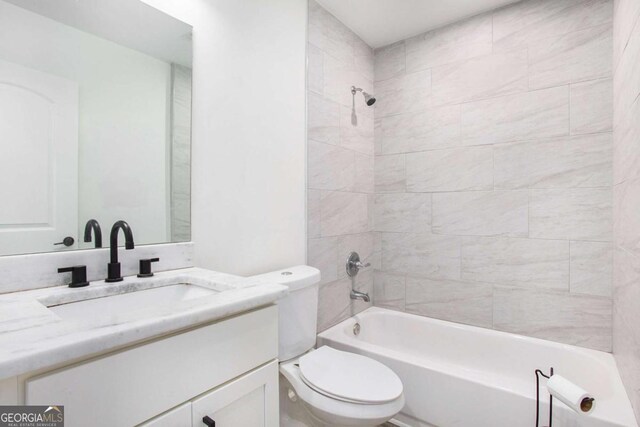 full bathroom featuring vanity, toilet, and tiled shower / bath