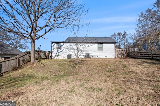 back of property with a yard and central AC unit