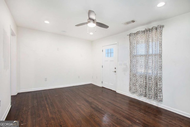 spare room featuring ceiling fan and dark wood-type flooring