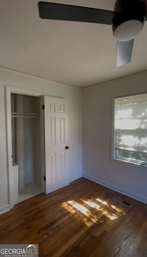 unfurnished bedroom featuring a closet and dark wood-type flooring