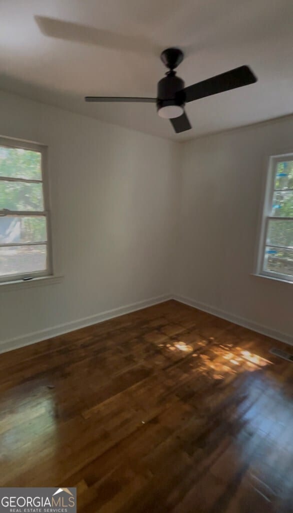 unfurnished room featuring ceiling fan and dark hardwood / wood-style flooring