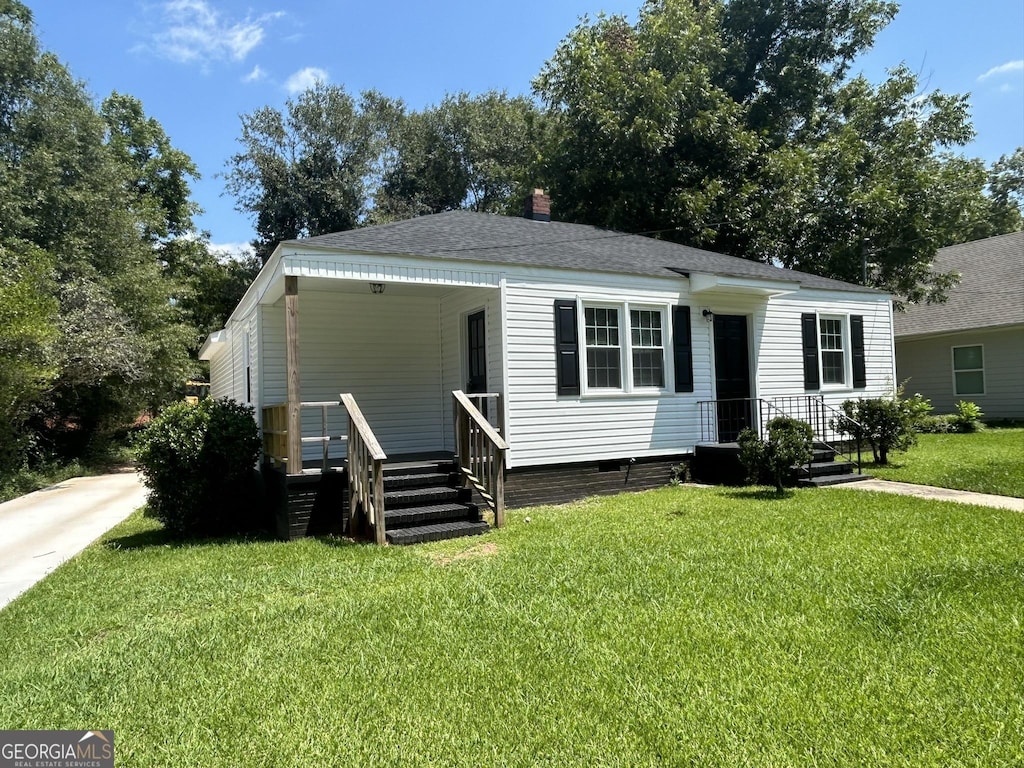 view of front of home with crawl space, a front lawn, roof with shingles, and a chimney