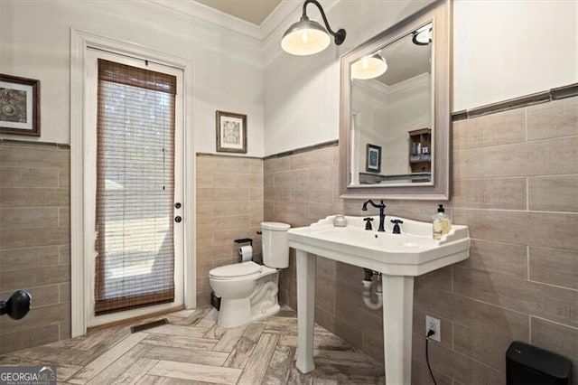 bathroom with toilet, tile walls, and ornamental molding