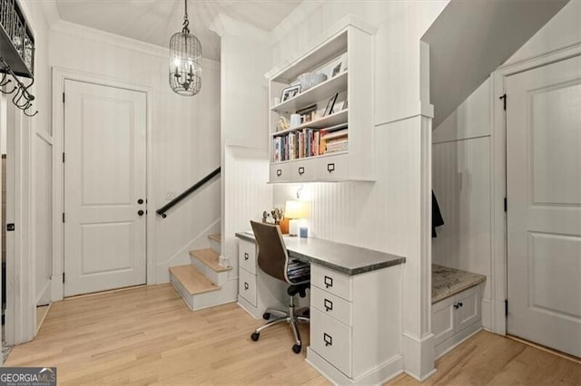 office with light hardwood / wood-style floors, crown molding, and a chandelier