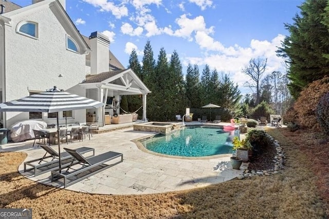 view of pool featuring an in ground hot tub and a patio