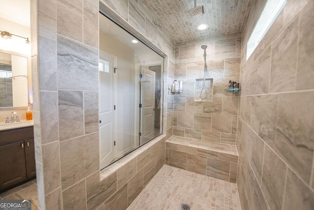 bathroom with vanity and tiled shower