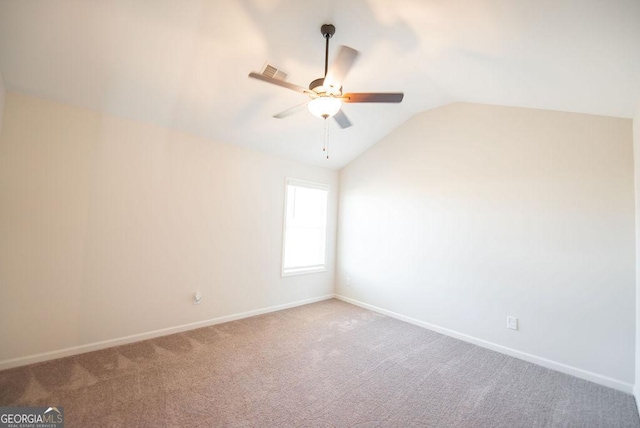 carpeted empty room with ceiling fan and vaulted ceiling