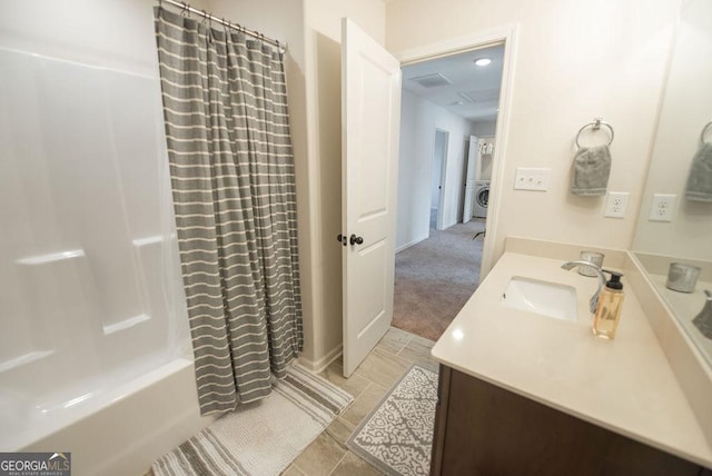 bathroom featuring vanity, shower / bath combination with curtain, and washer / dryer