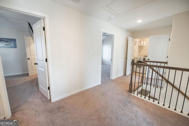 corridor featuring washer / clothes dryer and light colored carpet