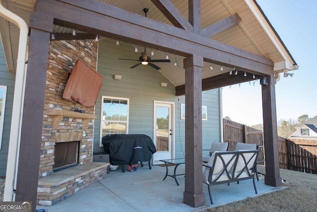 view of patio / terrace featuring area for grilling, ceiling fan, and an outdoor stone fireplace