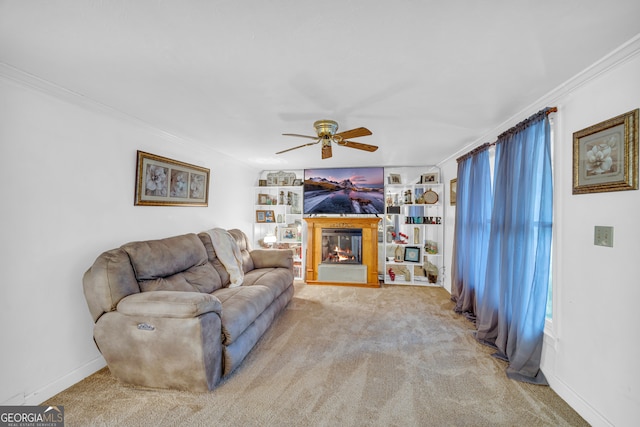 carpeted living room with crown molding and ceiling fan