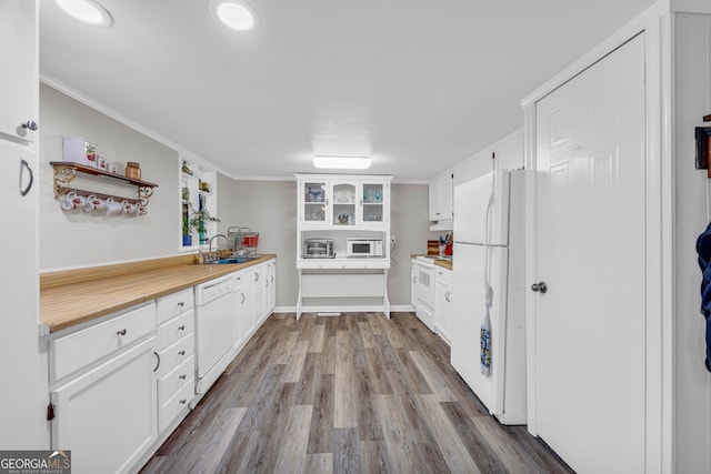 kitchen with crown molding, white cabinets, and white appliances