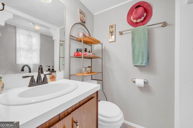 bathroom with crown molding, vanity, and toilet