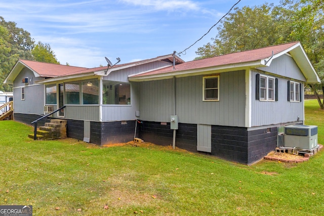 exterior space featuring a lawn, central AC, and a sunroom