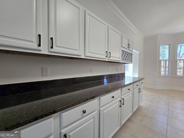 kitchen featuring white cabinets, dark stone counters, and light tile patterned floors