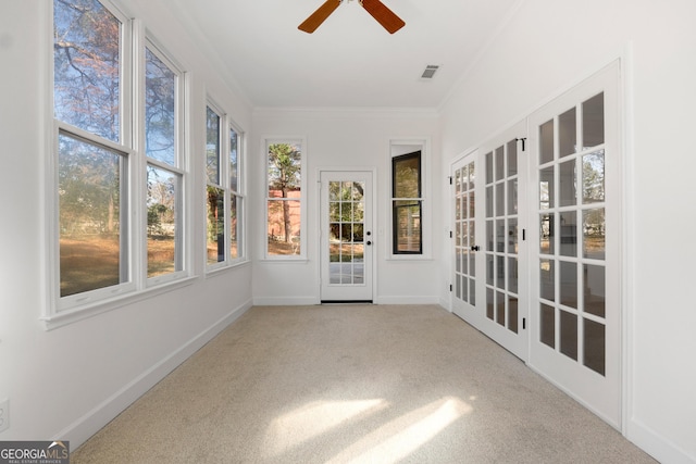 unfurnished sunroom featuring ceiling fan and french doors