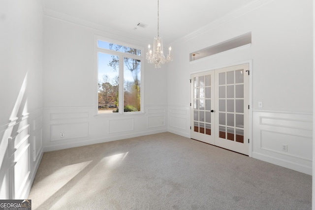 unfurnished dining area featuring carpet flooring, french doors, ornamental molding, and a notable chandelier