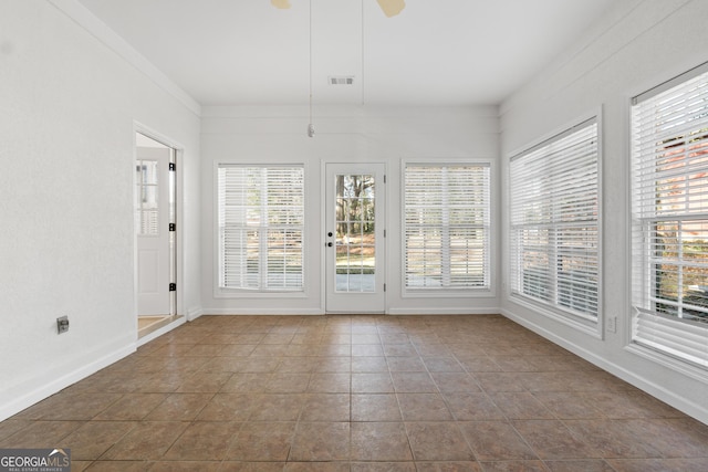 unfurnished sunroom with ceiling fan and a wealth of natural light