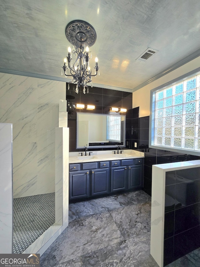 bathroom with crown molding, vanity, a chandelier, and tile walls