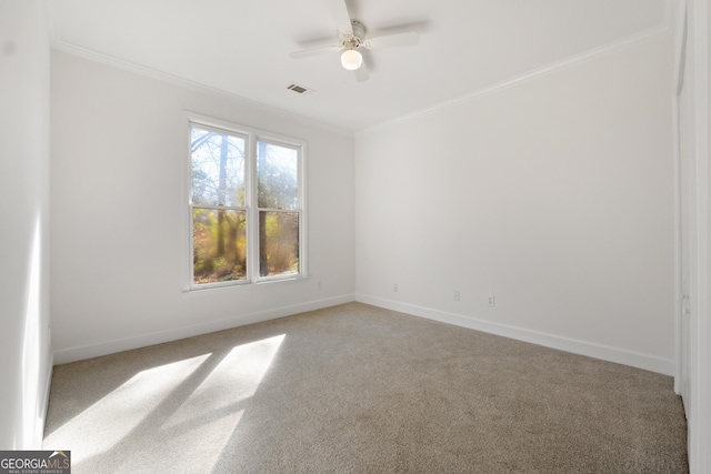 carpeted spare room featuring ceiling fan and crown molding