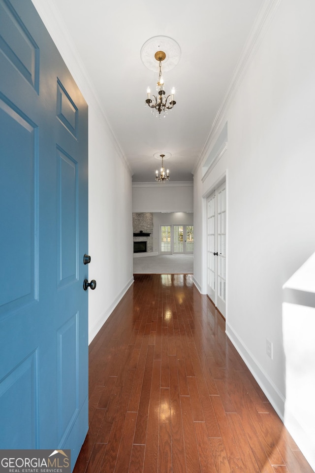 hallway with dark hardwood / wood-style flooring, a chandelier, and ornamental molding