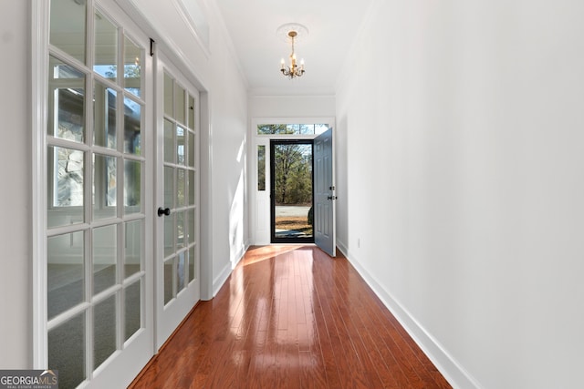 doorway featuring crown molding, french doors, hardwood / wood-style flooring, and a notable chandelier