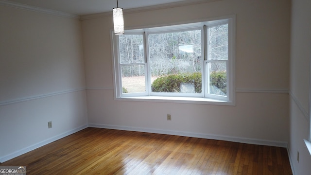 unfurnished room featuring hardwood / wood-style floors and crown molding