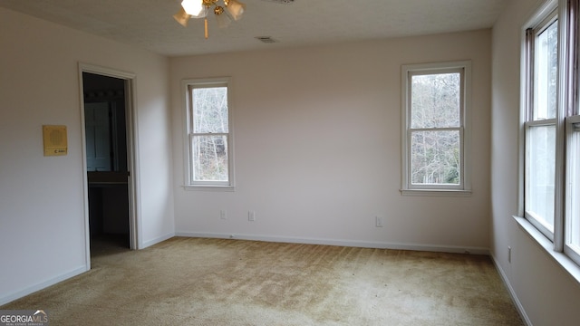 spare room with ceiling fan and light carpet