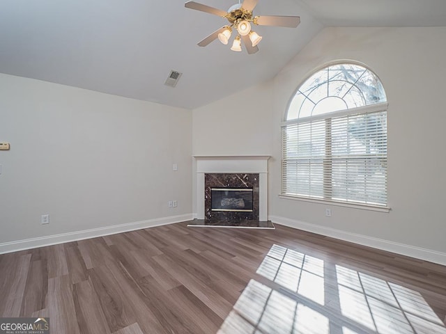 unfurnished living room featuring a fireplace, wood-type flooring, vaulted ceiling, and ceiling fan