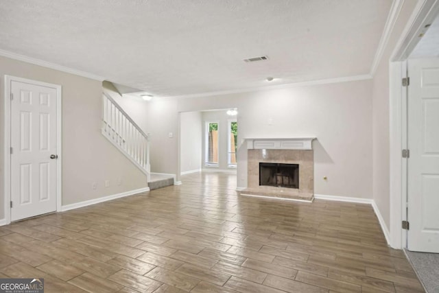 unfurnished living room featuring a textured ceiling and ornamental molding