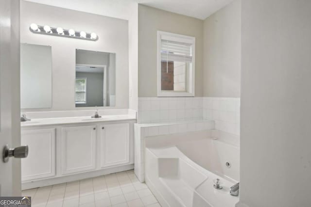 bathroom featuring tile patterned flooring, vanity, and a tub to relax in