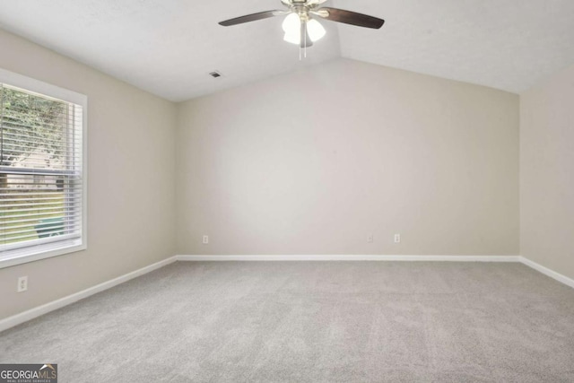 carpeted empty room with ceiling fan and lofted ceiling