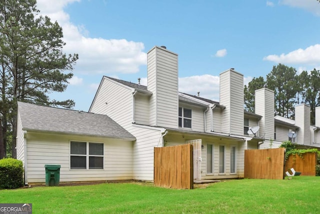 rear view of property with a lawn