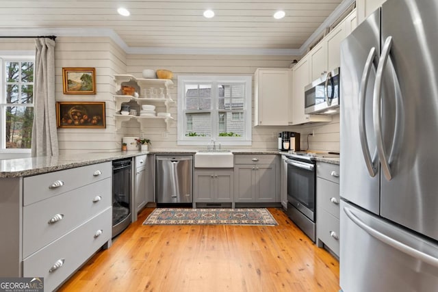 kitchen with light stone countertops, sink, beverage cooler, gray cabinets, and appliances with stainless steel finishes