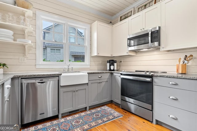 kitchen featuring gray cabinetry, white cabinetry, sink, stainless steel appliances, and light hardwood / wood-style flooring