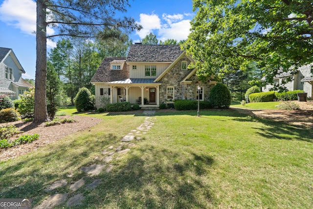 view of front of home with a porch, a standing seam roof, a front lawn, and board and batten siding