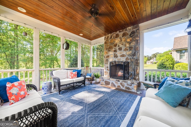 sunroom featuring a wealth of natural light and an outdoor living space with a fireplace